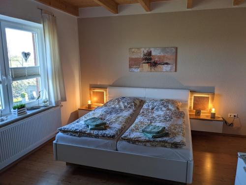 1 dormitorio con 1 cama con 2 lámparas y 2 ventanas en Landambiente Hage, en Halbemond