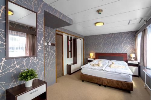 a bedroom with a large bed and a large window at Botel Vodnik in Prague