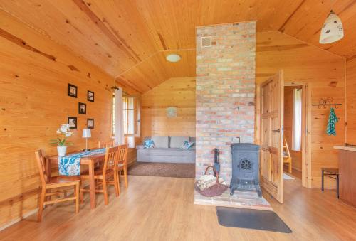 a living room with a fireplace and a table and a stove at Domki Dzika Róża in Darłowo