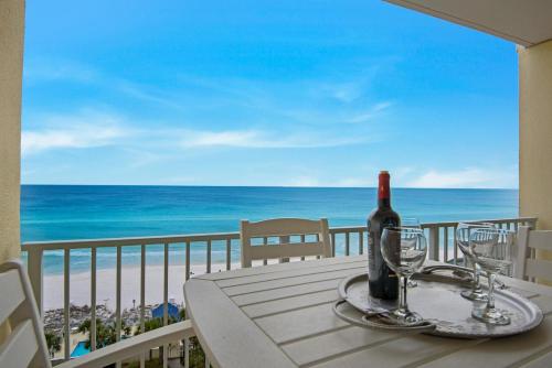 a bottle of wine sitting on a table with a view of the beach at Leeward Key 905- Suite Sea-Cret in Destin
