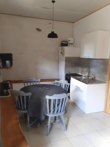 uma cozinha com mesa e cadeiras num quarto em Penandaouent em Commana