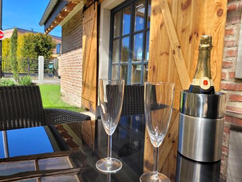 une bouteille de vin et deux verres sur une table dans l'établissement Maison Casteljaloux, à Heiteren