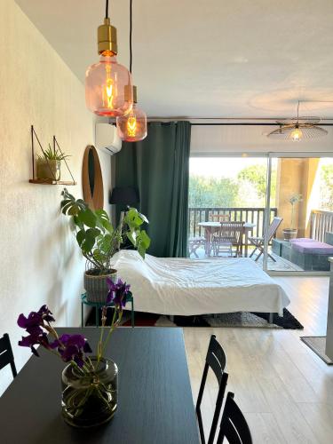 a bedroom with a bed and a table with plants at loumax in Gassin