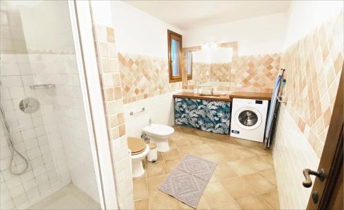 a bathroom with a toilet and a washing machine at Apartment Ida Isuledda 1 in San Teodoro