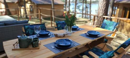 une table en bois avec des assiettes et des verres bleus dans l'établissement Domek Borsk nad samym jeziorem, à Borsk