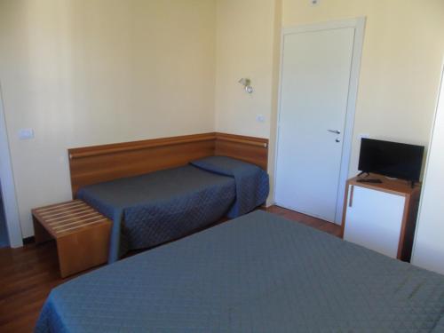 a small room with two beds and a television at Affittacamere Bel Sole in Borghetto di Vara