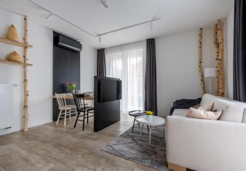 a living room with a white couch and a tv at Apartmány u Lesa in Dolní Morava