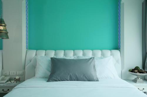 a bedroom with a white bed with a blue headboard at The Verandah - SHA Extra Plus in Ao Nang Beach
