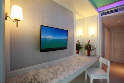 a living room with a television on a wall at The Verandah - SHA Extra Plus in Ao Nang Beach