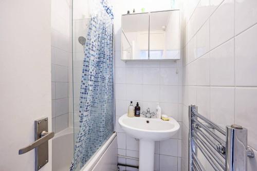 a white bathroom with a sink and a shower at 1-double bedroom aparment in Central London in London