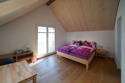 a bedroom with a purple bed and a window at Bed and Breakfast Wegmann in Andelfingen