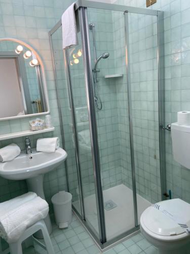 a bathroom with a shower and a toilet and a sink at Hotel Bahia in Caorle