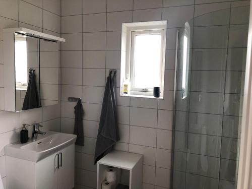 a bathroom with a sink and a toilet and a window at Gotland Tofta, Stuga med superläge! Havsutsikt på Tofta strand mindre än 10 minuter till en av Sveriges högst rankade golfbana! in Visby