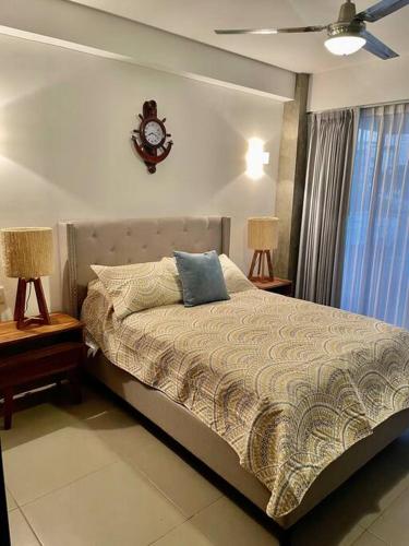a bedroom with a bed with a clock on the wall at Departamento bellísimo a 10 minutos de la playa in Nuevo Vallarta
