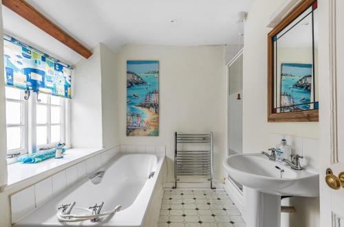 een witte badkamer met een bad en een wastafel bij Heydons House - Lovely Seaside Cottage in Sidmouth
