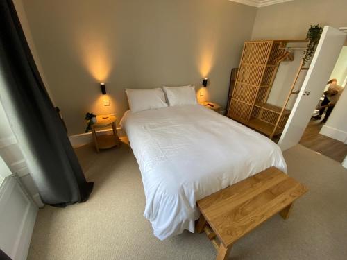 a bedroom with a large white bed and a table at The Central Guesthouse in Kelso