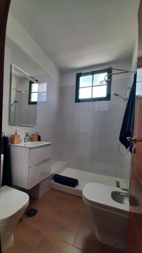 ein weißes Badezimmer mit Toilette und Waschbecken in der Unterkunft Omae Papagayo in Playa Blanca