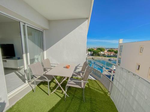 d'un balcon avec une table, des chaises et une piscine. dans l'établissement SUPERBE APPARTEMENT 47 m2, TRES CALME, à Palavas-les-Flots