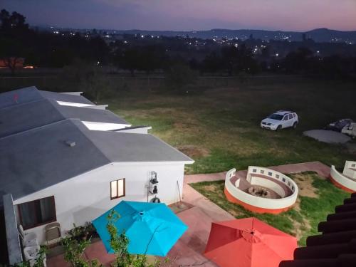 an aerial view of a house with umbrellas in a yard at VILLAZOL CABAÑAS in Zacatlán