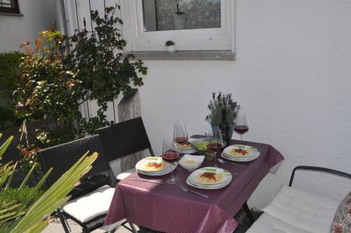 a purple table with plates of food and glasses of wine at Ferienwohnung Roth, Unlingen in Unlingen