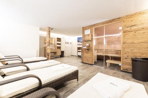 a room with three beds in a room with wooden walls at Appartements AUSZEIT with private SPA in Embach