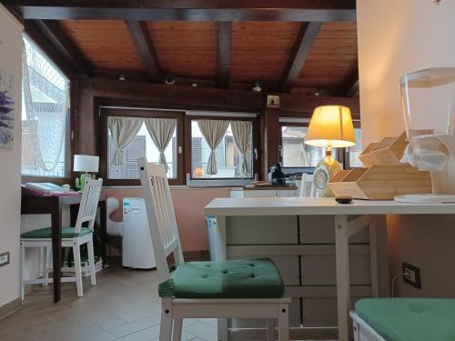 a kitchen with two chairs and a table with a lamp at IL Ritratto casa vacanza in Scilla