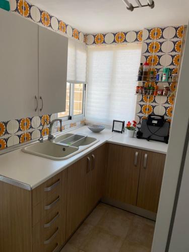uma cozinha com um lavatório e uma janela em Apartamento La Pobla de Farnals em Valência