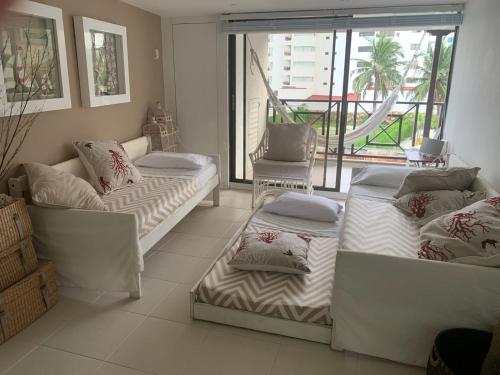 ein Wohnzimmer mit 2 Betten und einem Balkon in der Unterkunft Espectacular apartamento en San Andres Hansa Reef in San Andrés