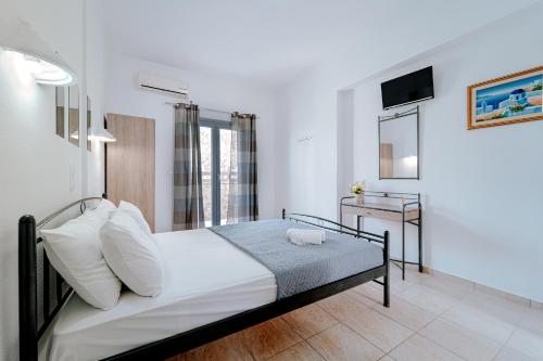 a bedroom with a large bed and a large window at Marousi Rooms in Perissa