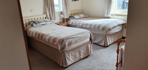1 dormitorio con 2 camas y ventana en Victoria Farm, en Lutterworth