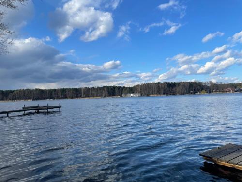 a view of a lake with a wooden dock at Dom nad jeziorem Sławskim in Lubiatów
