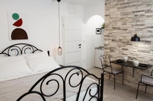 - une chambre avec un lit, une table et des chaises dans l'établissement Vinea Suites, à Trogir