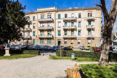 un gran edificio con coches estacionados en un estacionamiento en Lady of Health Apartments, en Zadar
