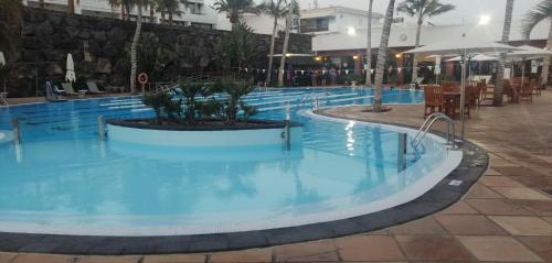 a pool at a resort with blue water at Apartamentos Temisa in Puerto del Carmen