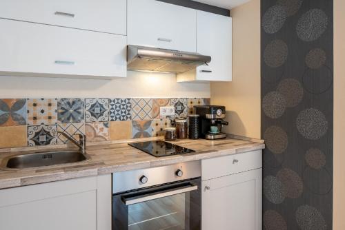a kitchen with white cabinets and a sink at TREEHOUSE - KiDS PARADISE - CENTRAL - SSC in Winterberg