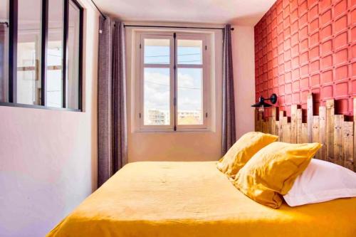 um quarto com uma cama com lençóis amarelos e uma janela em SUITE LAMARTINE em Saint-Raphaël