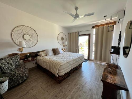 哥德普洛谷的住宿－Rincón del Corazón，一间卧室配有一张床、一张沙发和风扇