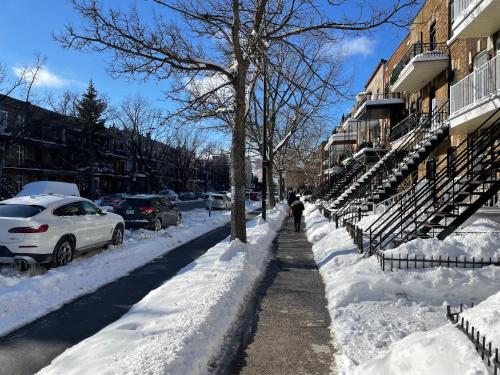 a person walking down a snow covered street at Chambres EL MEDITERRANEO Rooms in Montréal