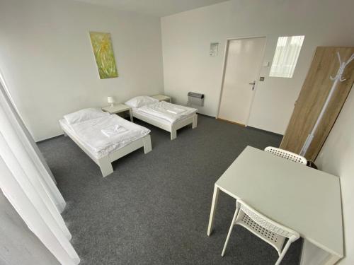 a room with two beds and a table and chairs at Ubytovna Kubra in Hodonín