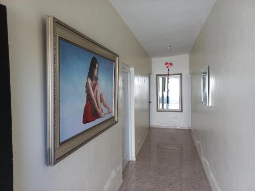 einen Flur mit einem Bild einer Frau an der Wand in der Unterkunft Turnbull's Apart Hotel in Consuelo