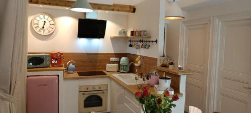 a kitchen with a sink and a clock on the wall at Le Maréchal Duplex - Appartement avec Jacuzzi - CAEN hyper Centre in Caen