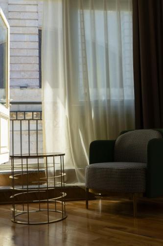 a living room with a couch and a window at Grand Opera Hotel in Kutaisi