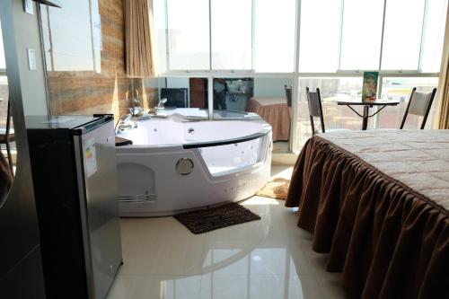 baño con lavabo y bañera junto a la cama en Hotel Puma'r Tacna, en Tacna
