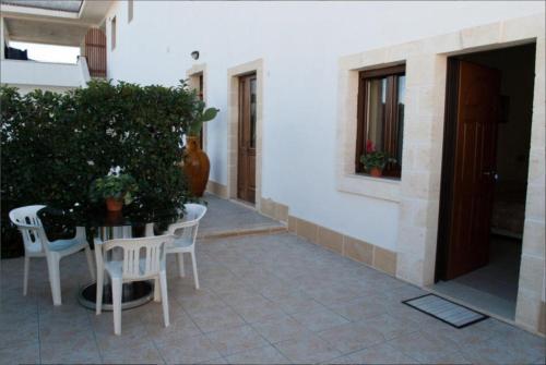 a patio with a table and chairs and a plant at Masseria Lama D'impisa in Fasano