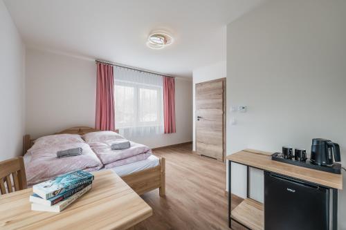 um quarto com uma cama e uma mesa num quarto em Willa Cichosza - wygodne i nowoczesne pokoje, 800m do centrum tuż przy szlakach pieszych i rowerowych oraz stokach narciarskich em Szczawnica