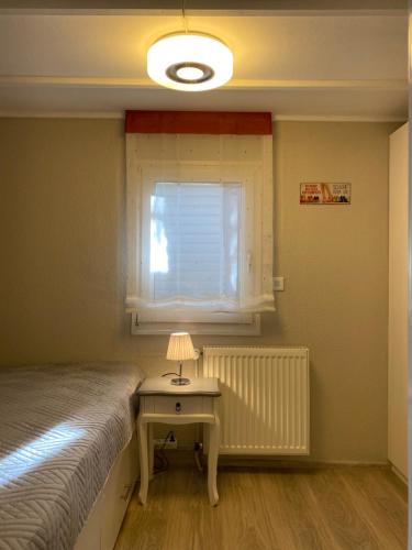 a bedroom with a bed and a table with a lamp at S-CHALET Camping mit Comfort im Schwarzwald in Steinach