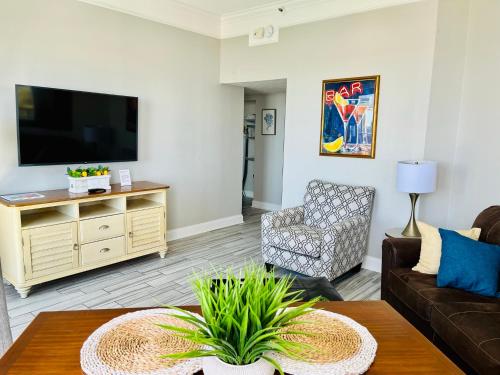 a living room with a couch and a tv at 210 Sea Gem Oceanfront Pet Friendly Oceanfront in Myrtle Beach