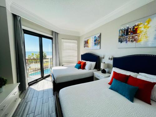 a bedroom with two beds and a large window at 210 Sea Gem Oceanfront Pet Friendly Oceanfront in Myrtle Beach