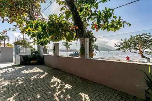una pared con vistas al agua y a un árbol en Aptos e Studios de frente para a Lagoa da Conceição SDR, en Florianópolis