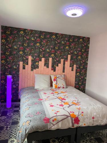 - une chambre avec un lit orné de motifs floraux dans l'établissement Maison rez-de-chaussée 3 étoiles confortable, à Noyelles-sur-Mer